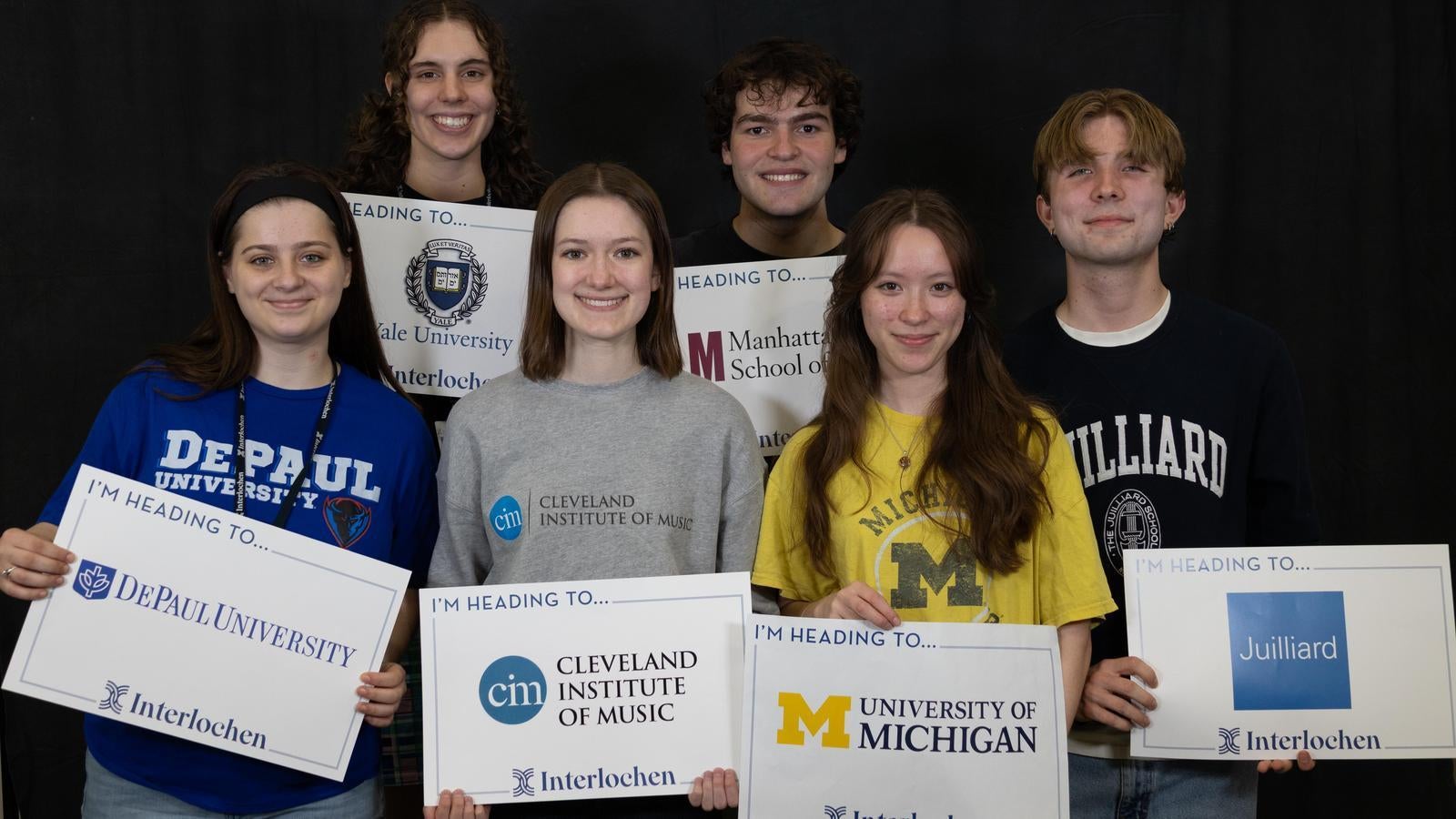 Interlochen Arts Academy seniors hold up signs to where they're going to college:Yale, Juilliard, University of Michigan, and more.