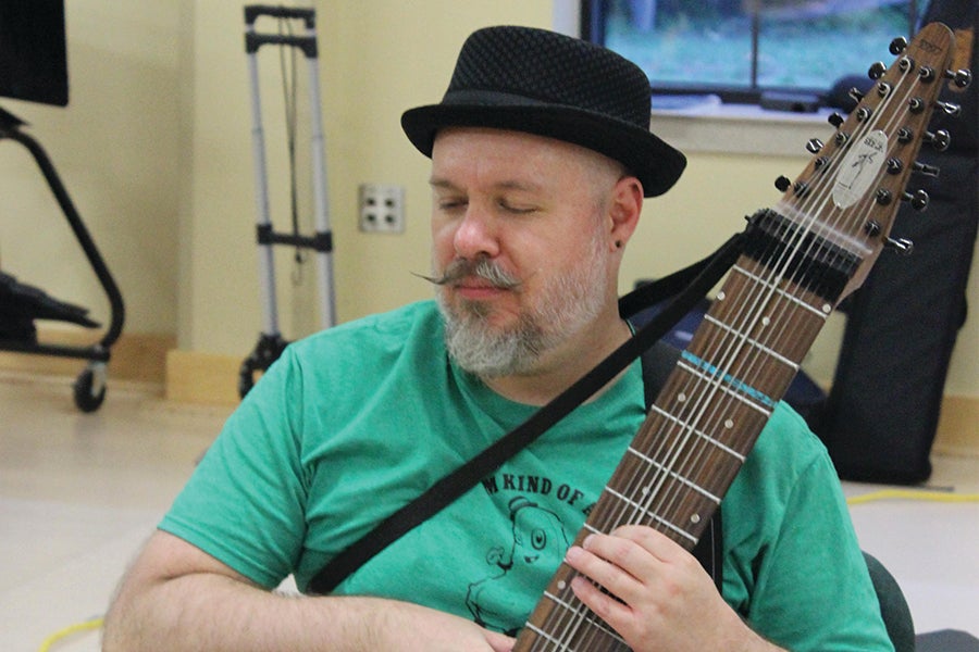 Man tuning a Chapman Stick