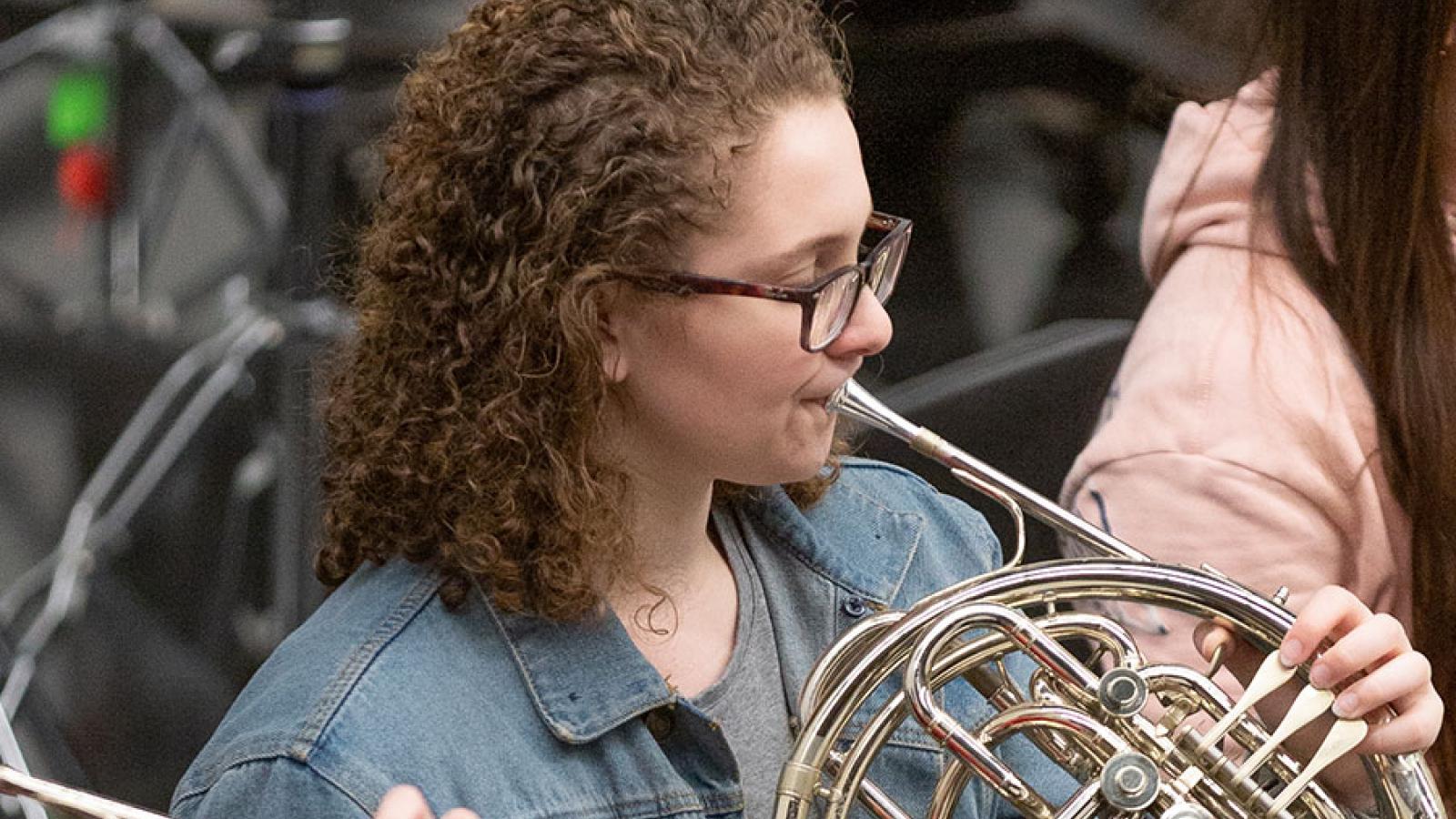 A girl plays horn