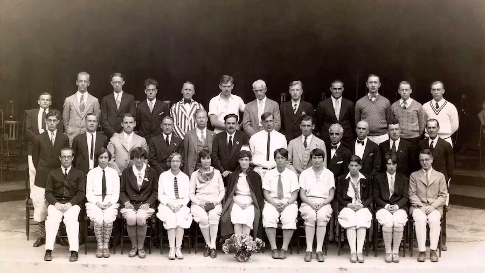 Black-and-white group photo of thirty-five faculty and staff  in formal or semi-formal attire, arranged in three rows.