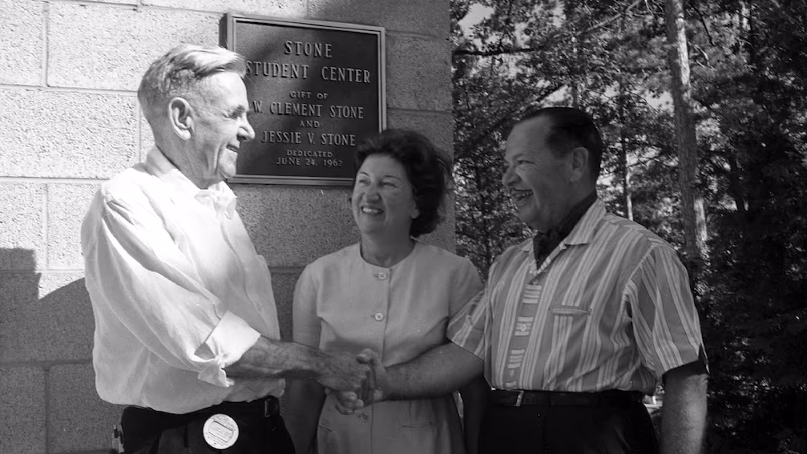Joseph Maddy shakes hands with W. Clement Stone as Jesse V. Stone looks on at the dedication of the Stone Student Center in 1962. 