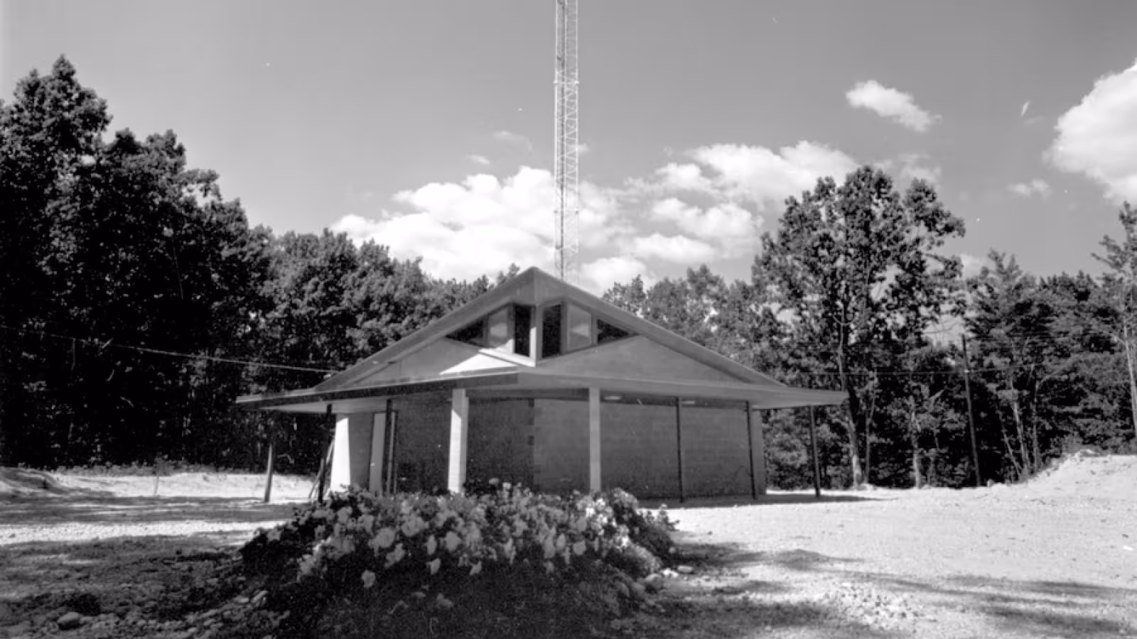 Black and white photo of the newly opened WIAA radio station under the radio tower. 