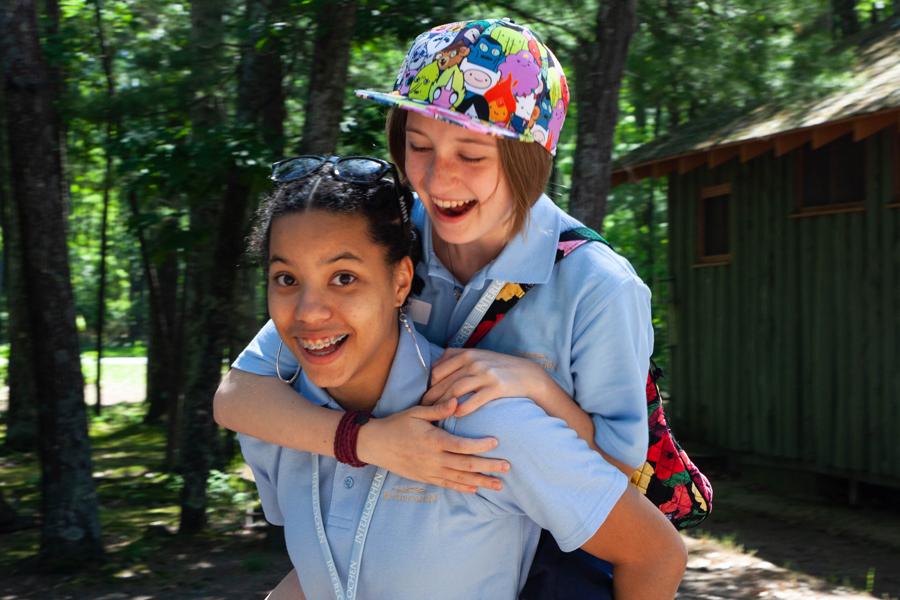 Student give piggyback ride to other student at Interlochen Arts Camp