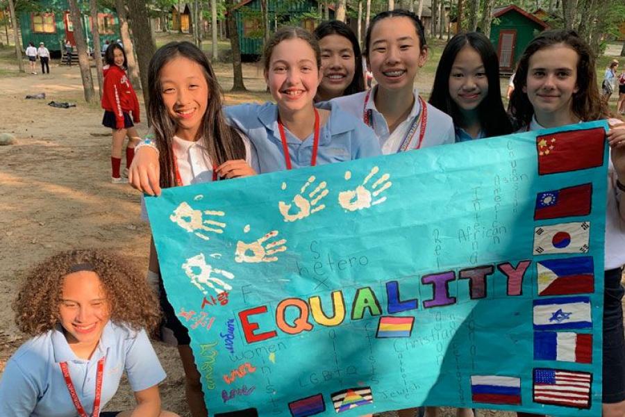 A group of intermediate students with a banner that reads "equality"