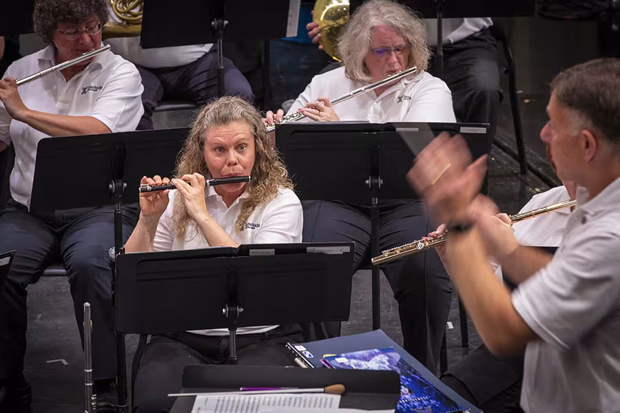 Photo of women playing in band concert with the conductor at the front