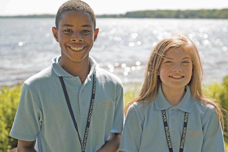 Two junior Interlochen Arts Camp students smile in front of lake
