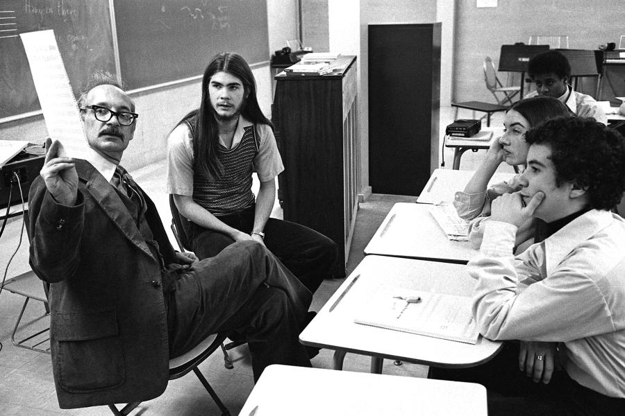 George Crumb sits with students