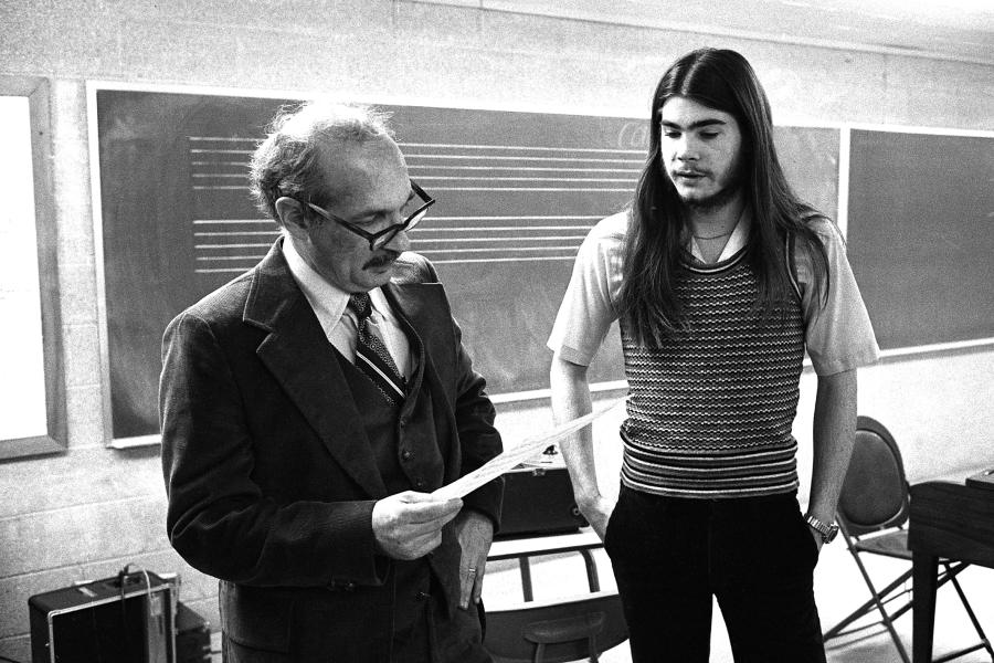 George Crumb stands next to student