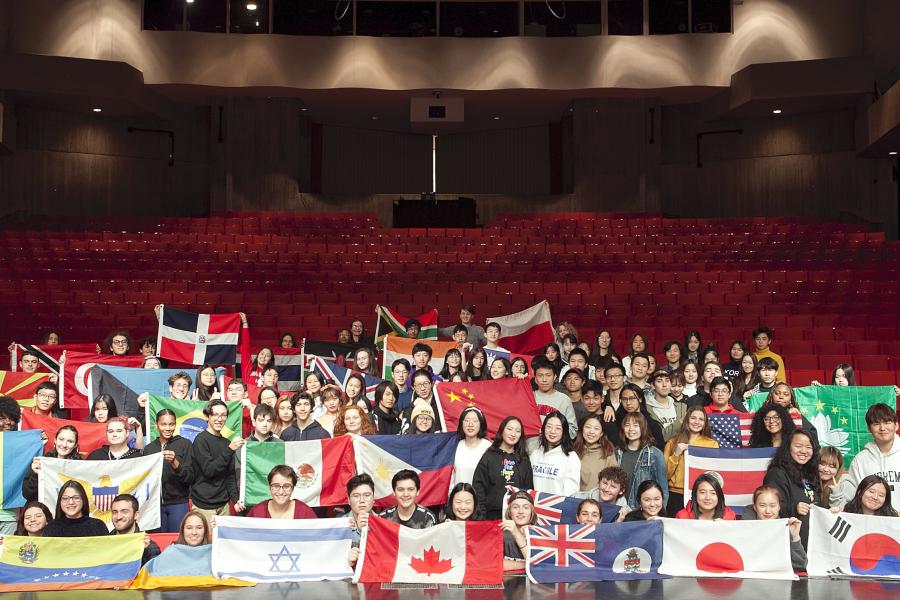 Interlochen Arts Academy international students with country flags inside Corson Auditorium