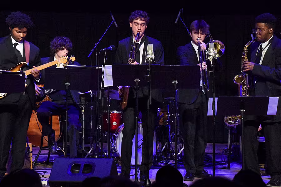 A student-lead jazz ensemble performing on stage. 