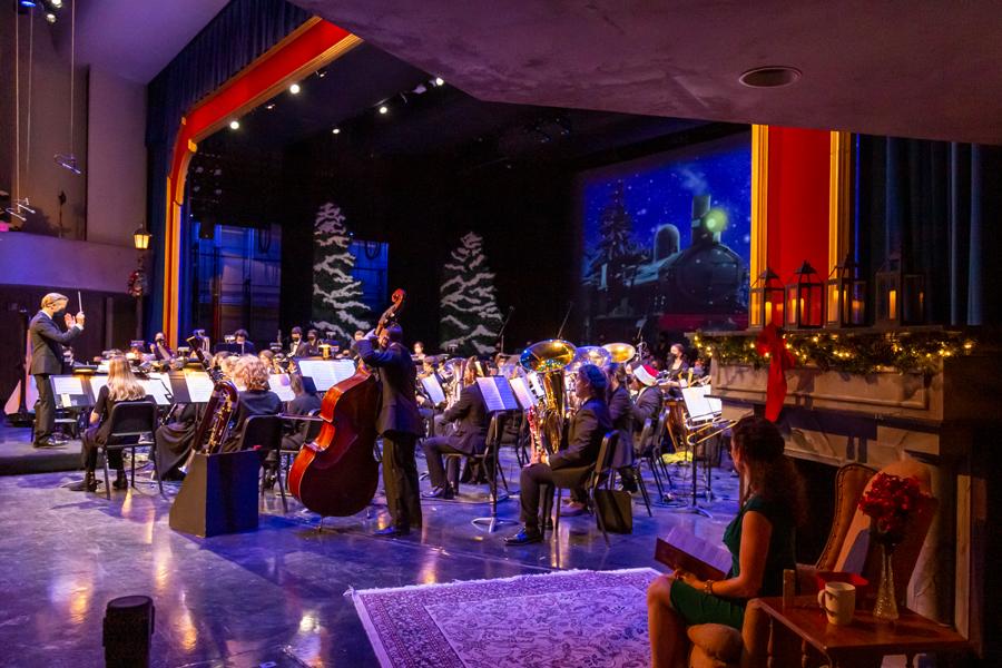 A festive stage with a student wind symphony performing songs of the holiday season