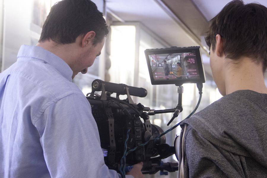 Two men working with a video camera on a film set.