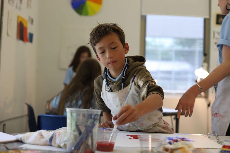 A boy painting in a class