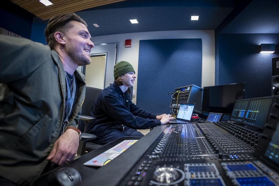 An instructor and a student use a digital interface to produce music.