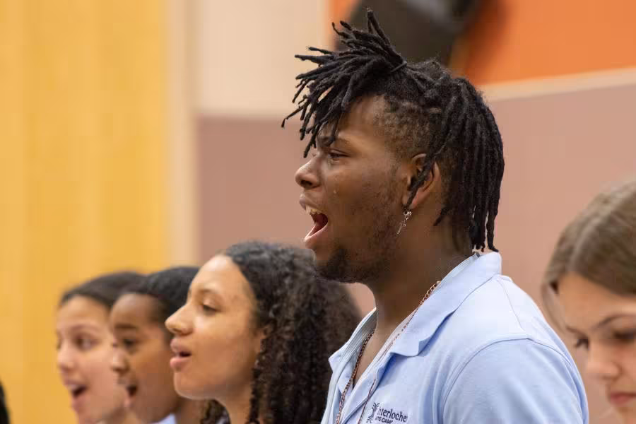 A group of students sing expressively.