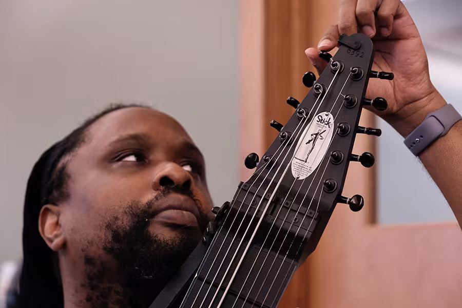 A man tuning a chapman stick instrument