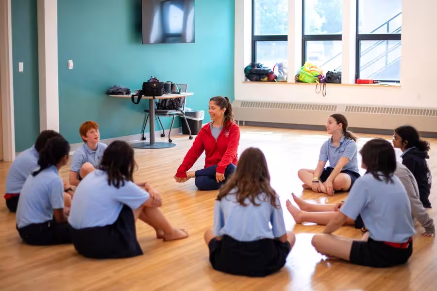 A circle of dance students sitting on the ground