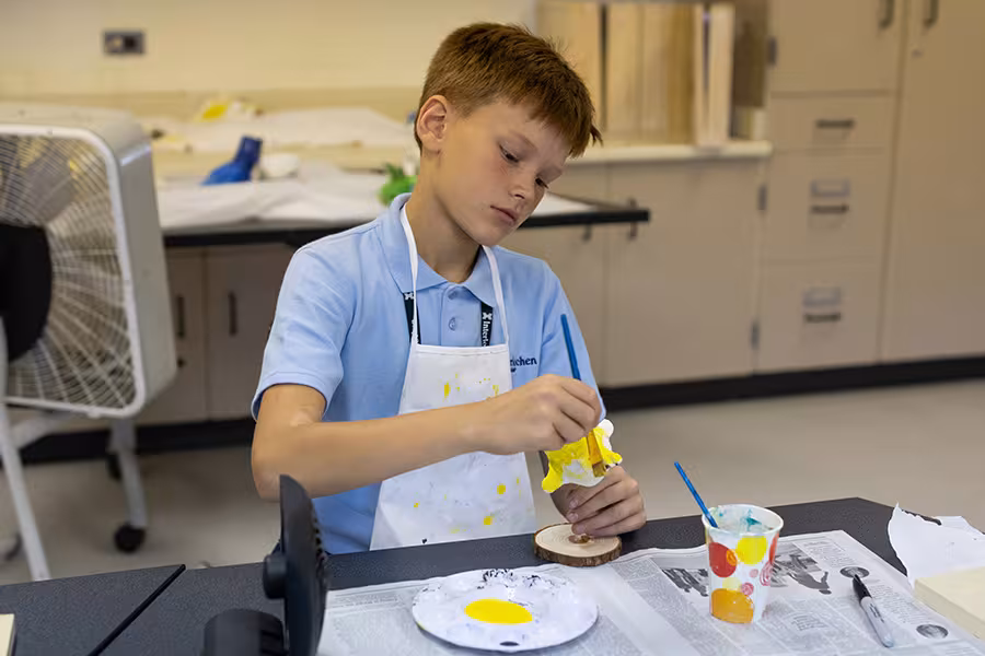 A camp student mixing paints