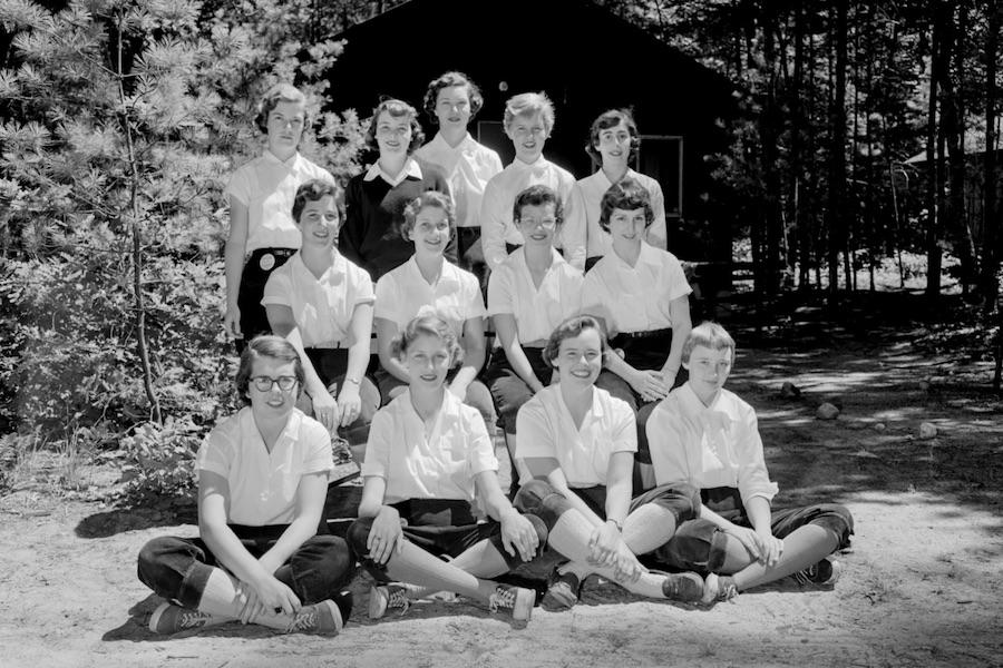 A group of female campers pose for a cabin photo.