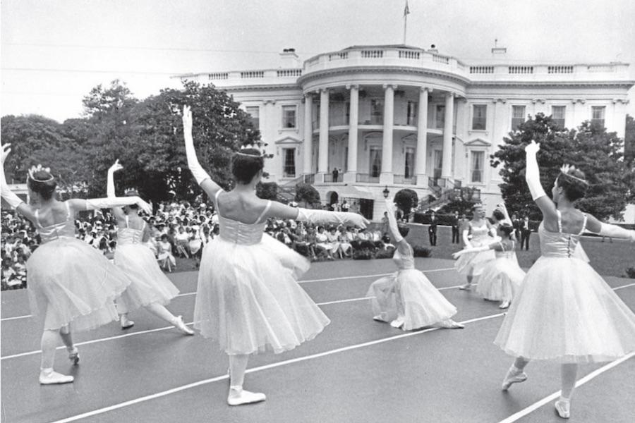 A group of young dancers wearing long tutus performs in front of the White House.