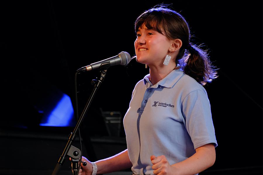 an image of a camp student performing at a microphone