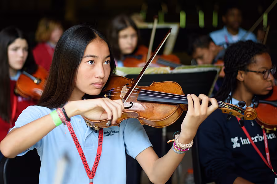 A camp student performing in an orchestra