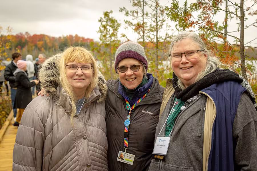 Mary Ellen Newport poses with two alumni during an event at Bridge Lake