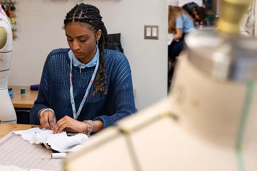An experimental fashion student works on a garment.
