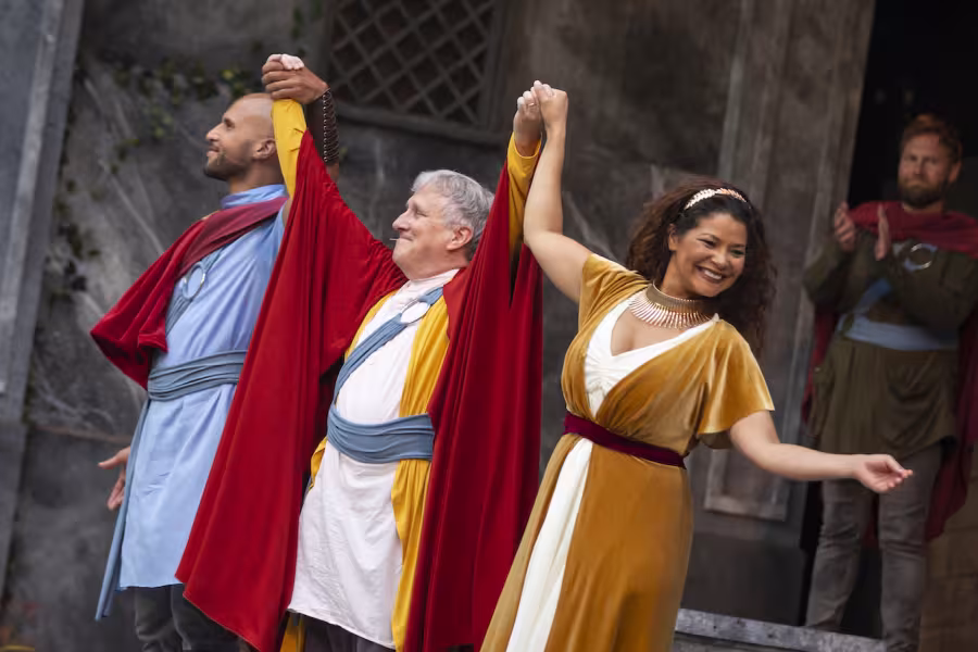 3 Interlochen students in a musical theatre raising their hands up in triumph 