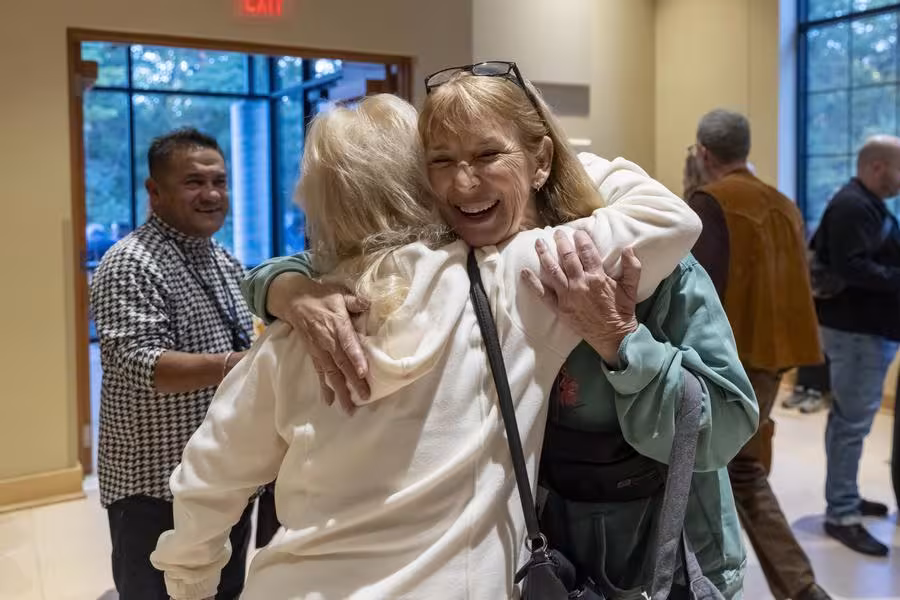 Two alumni share a hug.