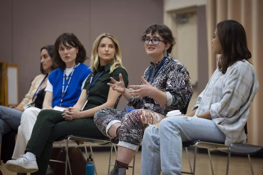 A group of people sit in a panel discussion.