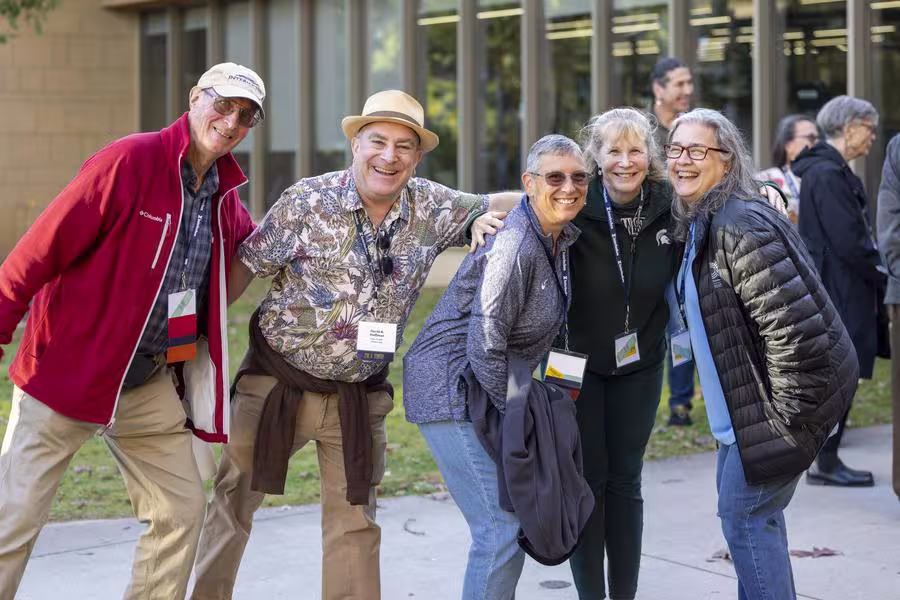 A group of alumni pose and smile.