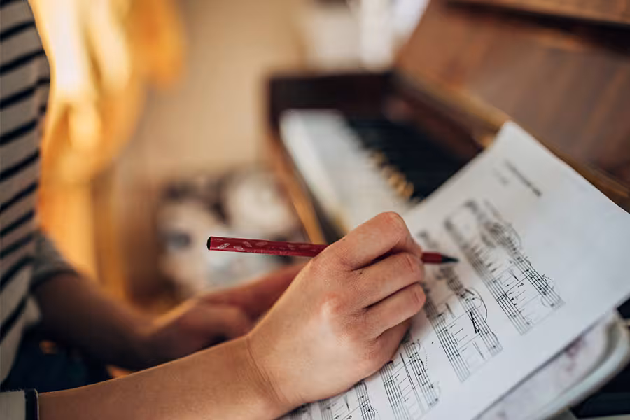 A woman writes on a piano score