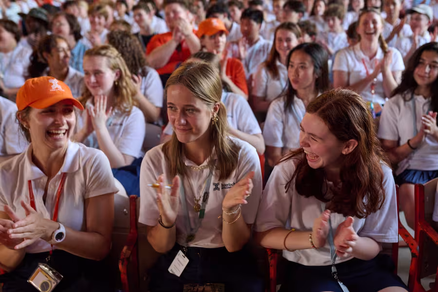 Students smile and clap in the audience at First Gathering.