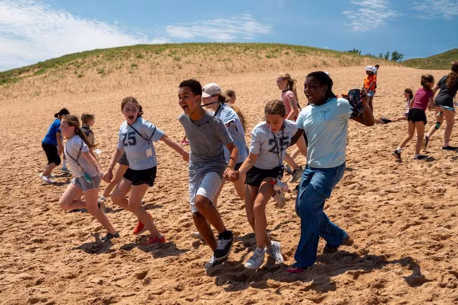 Students sprint down Sleeping Bear Dunes.