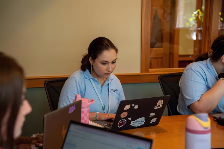A creative writing student works at their laptop in class.