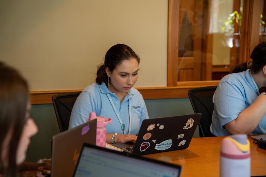 A creative writing student works at their laptop in class.