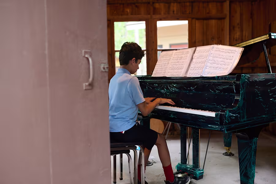 An intermediate piano student practices in one of Interlochen Arts Camp’s many practice cabins.