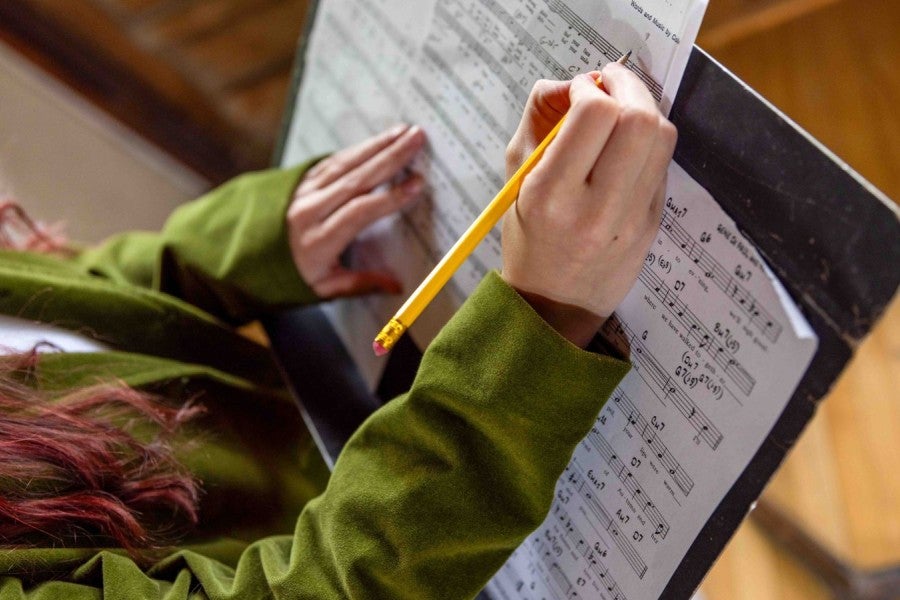 A woman writing on sheet music