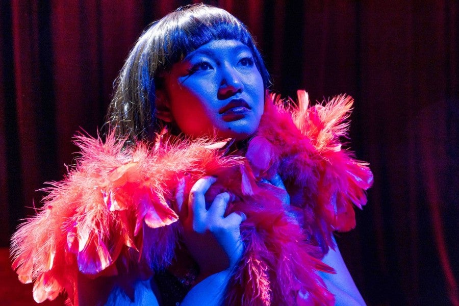 A girl on stage with dramatic lighting