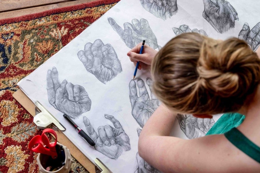 A girl drawing hand positions on the floor