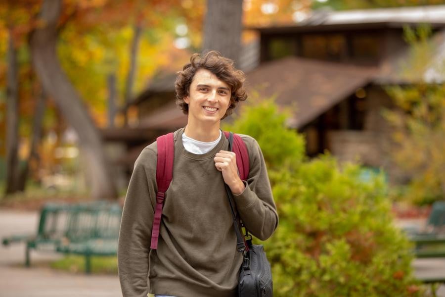 One Interlochen Arts Academy student smiles while walking to class in the fall season