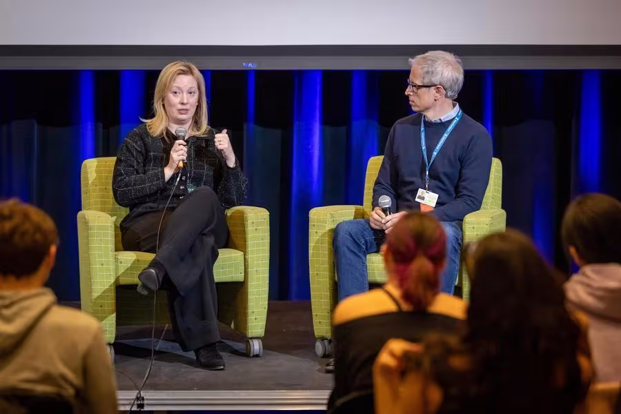 Two filmmakers address an audience of students.