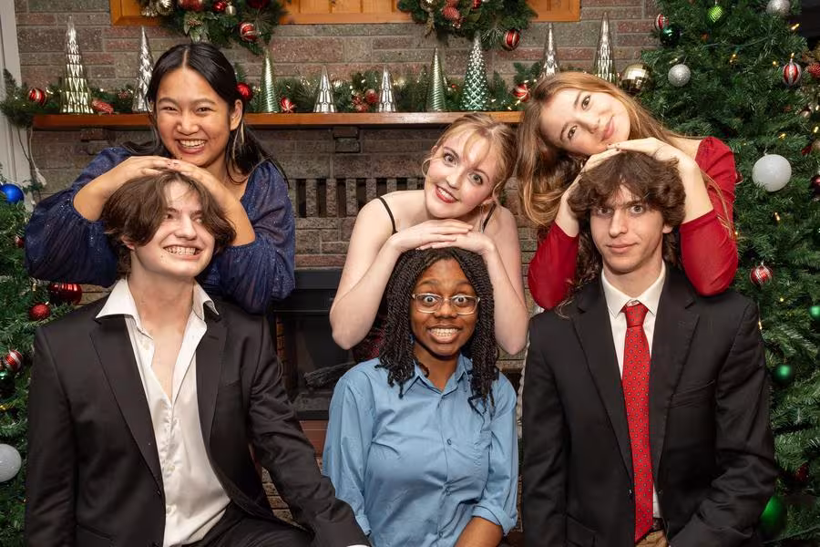 Holiday Dinner shot of Arts Academy students in front of Christmas trees