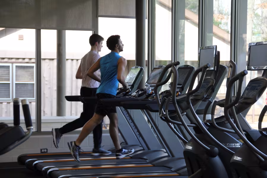 Two Interlochen Arts Academy students running on the treadmills at the Dennison Center