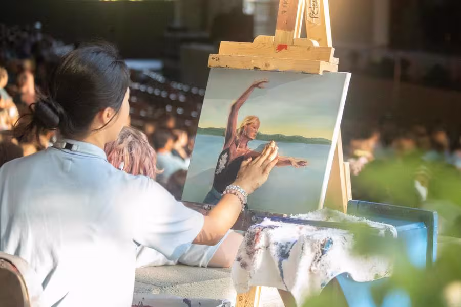 A high school painter creates a portrait of a dancer during “Collage.”