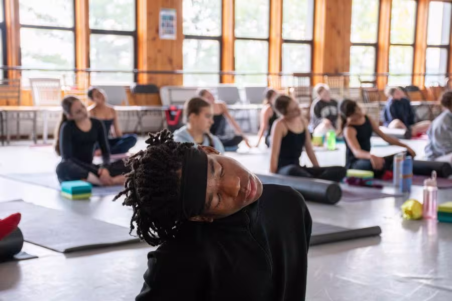 Dancers warm up with a group yoga session.