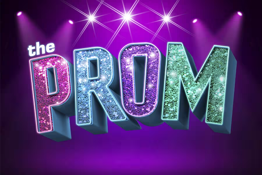 The The Prom logo appears on a purple background, with large glitter-covered letters in pink, blue, purple, and teal. Small white text reading "the" sits above the colorful title, creating a bold, festive design that reflects the musical's energetic and celebratory spirit.