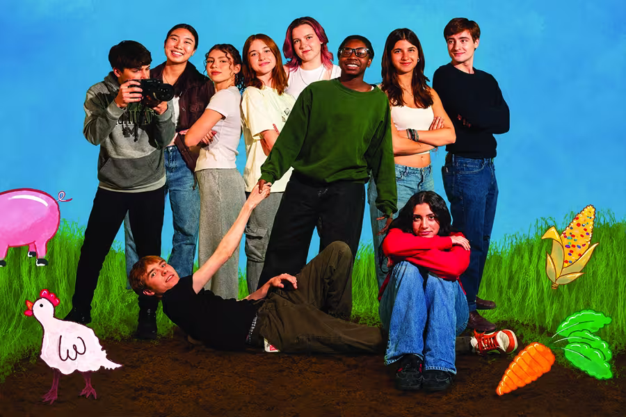 Group of nine young people posing outdoors in a grassy field, with one holding a camera and others sitting or standing around them. Hand-drawn illustrations of vegetables and animals surround the group.