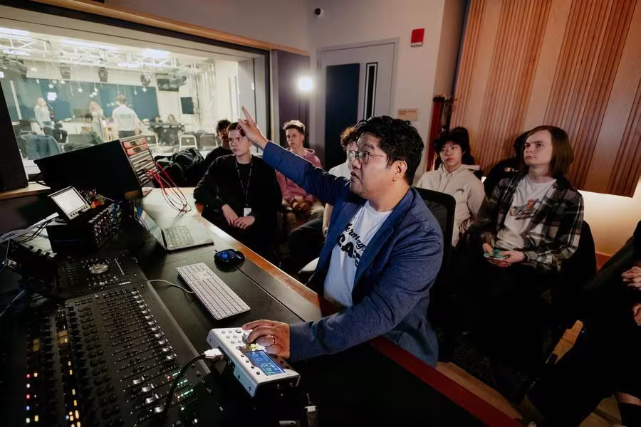An instructor teaches students about music production